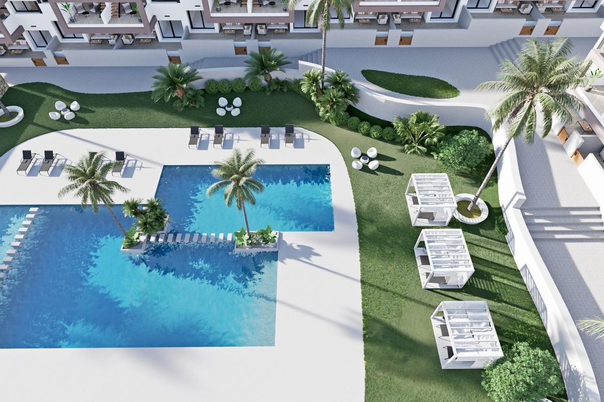 Luchtfoto van een ruime zwembadruimte in Finestrat met ligstoelen en tropische beplanting.