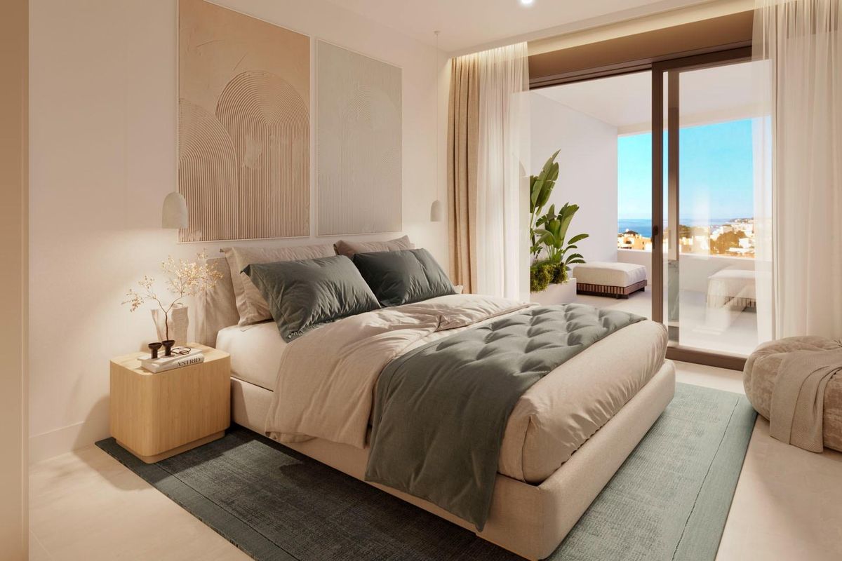 Elegant slaapkamer met luxe beddengoed en toegang tot een terras, biedt een ontspannen sfeer in de stadwoning van Fuengirola.
