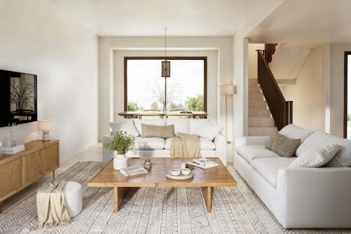 Helle woonkamer van de woning met witte banken en uitzicht op de tuin in La Nucia.