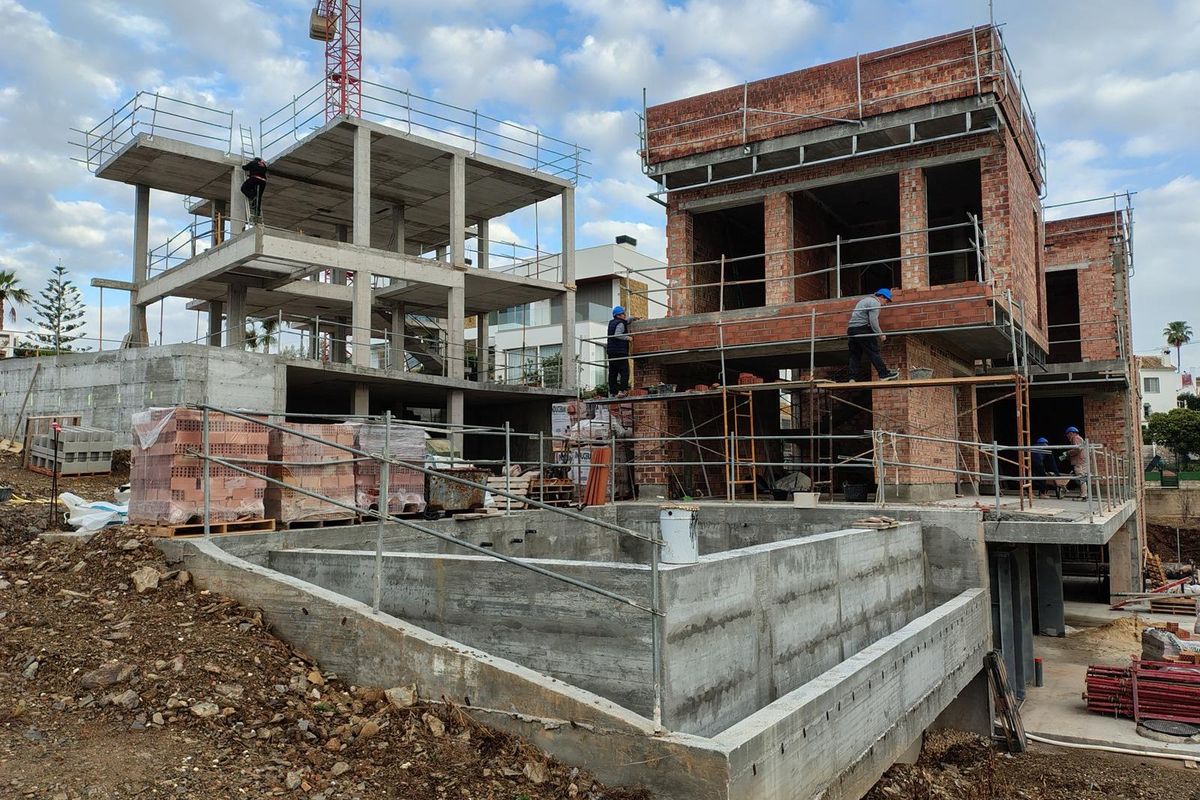 Bouwfoto van een nieuwe villa in aanbouw in Mijas, Costa del Sol, met arbeiders op locatie.