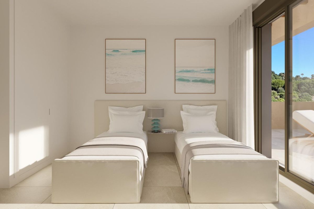 Gezellige slaapkamer met twee eenpersoonsbedden in een 2-slaapkamer appartement, San Roque, Costa del Sol, versierd met strandthema kunst.