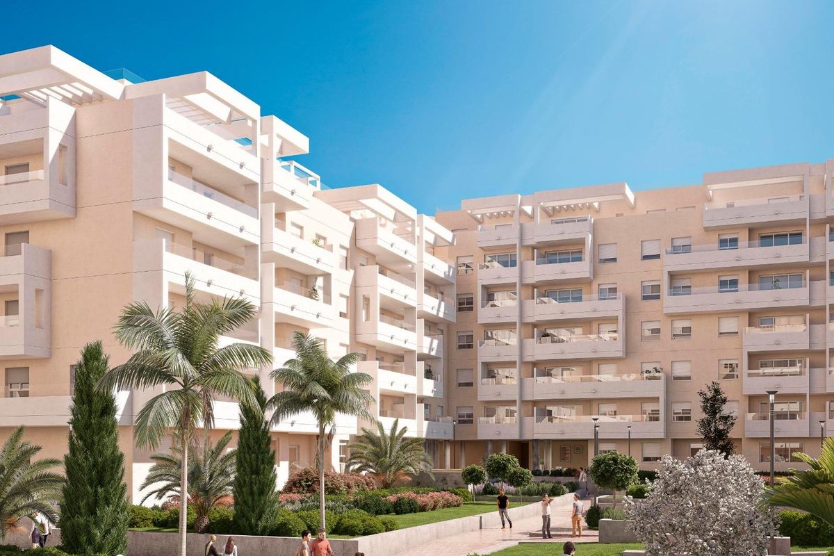 Heldere binnenplaatszicht van een appartementencomplex in Marbella, met bewoners die van de zonnige tuinen genieten.