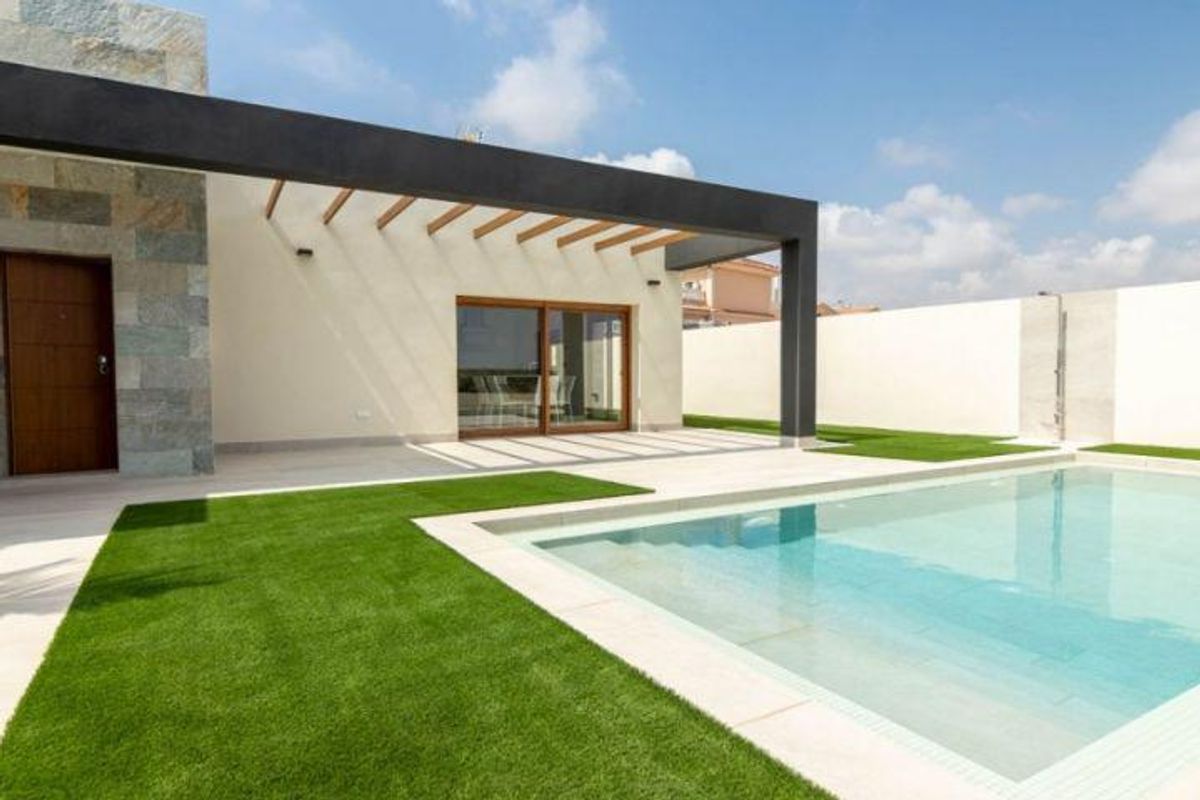 Moderne villa buitenkant met een zwembad en aangelegde tuin in Torrevieja, Costa Blanca.