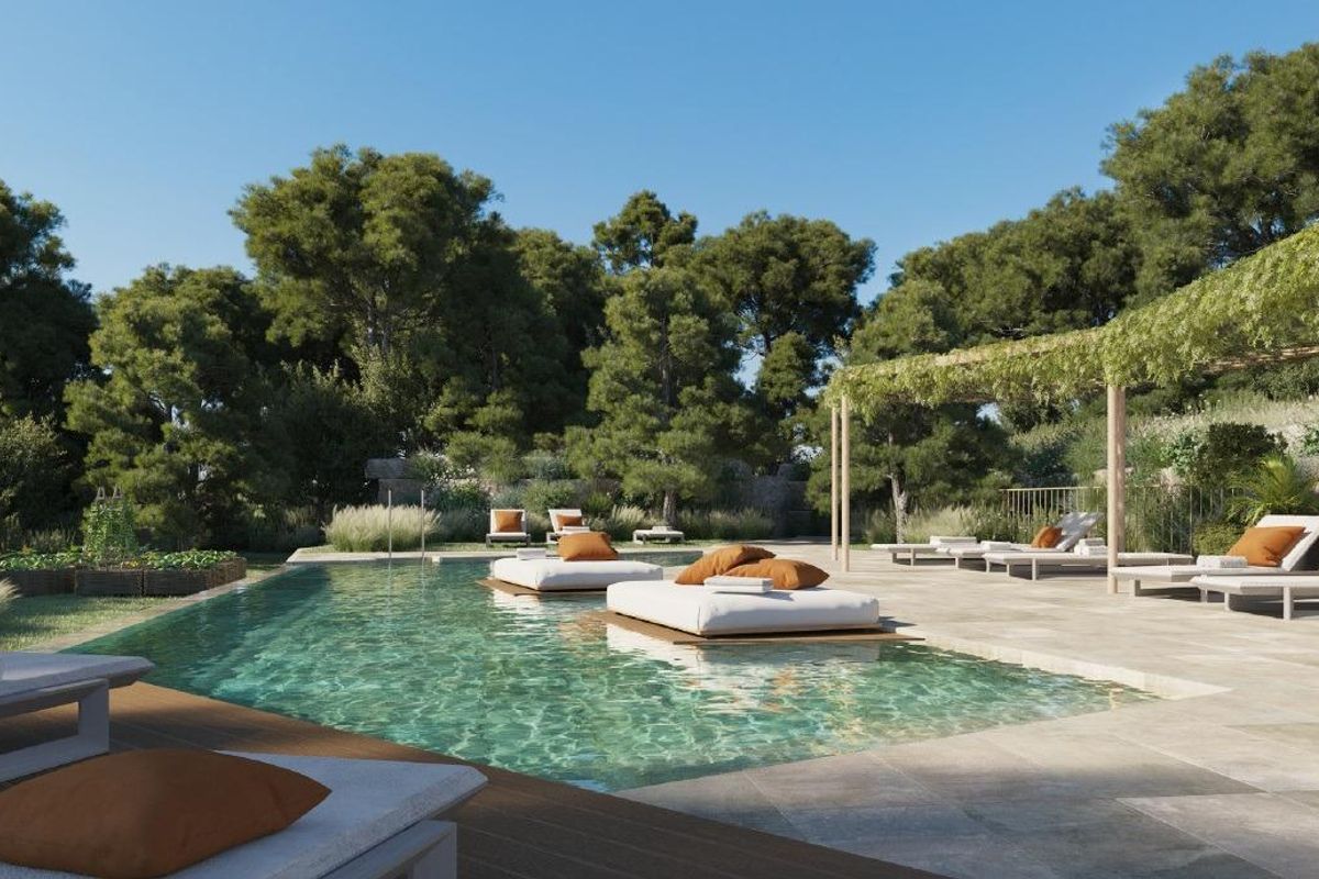 Buitenpool met ligstoelen omringd door weelderig groen in Fuengirola, Costa del Sol.