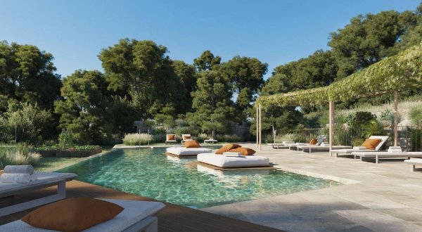 Buitenpool met ligstoelen omringd door weelderig groen in Fuengirola, Costa del Sol.