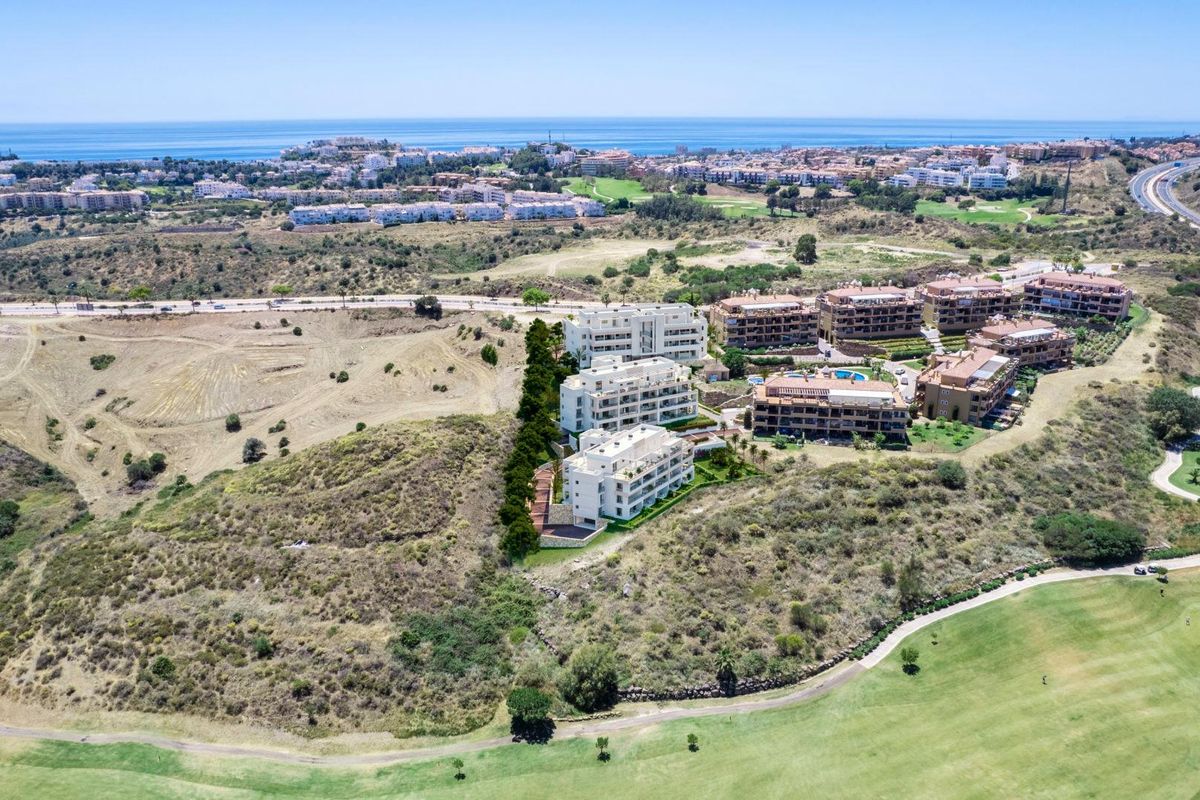 Luchtfoto van een 2-slaapkamer penthouse in Mijas, Costa del Sol, omgeven door schilderachtige heuvels en golfbanen.