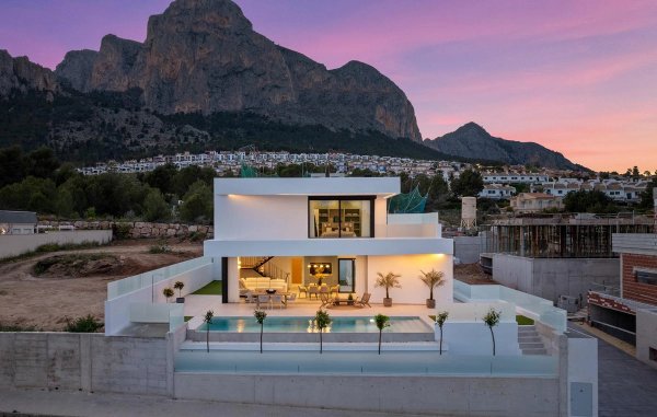 Moderne 3-slaapkamer villa in Polop met zwembad, omgeven door bergen bij zonsondergang.