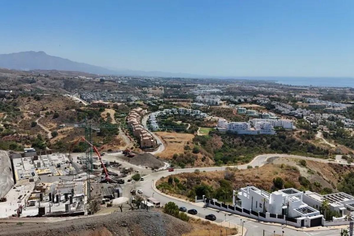Luchtfoto van de bouwplaats in Estepona, Costa del Sol, met voltooide appartementen en een schilderachtige achtergrond.