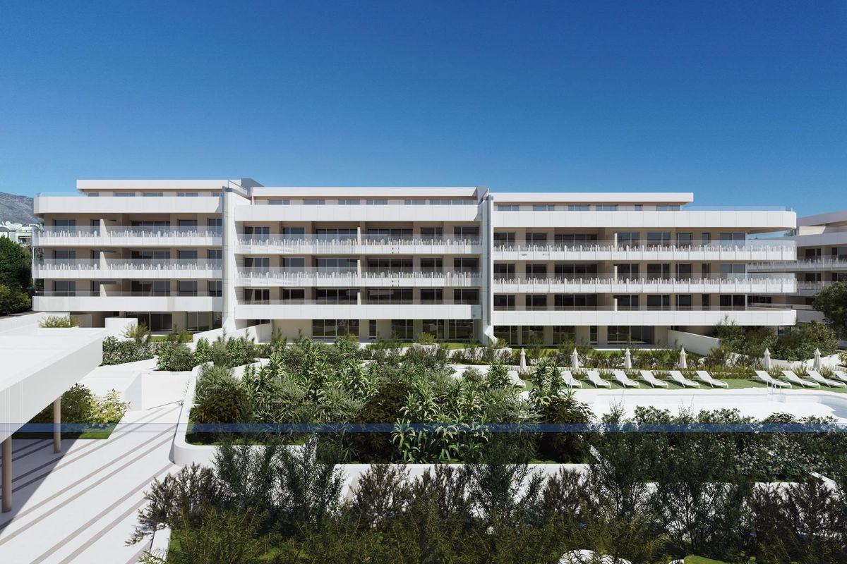 Facade van een stijlvol appartementencomplex in Marbella met moderne balkons en aangelegde tuin.