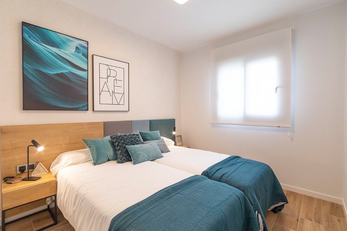 Tweede slaapkamer in een appartement in Benidorm met twee eenpersoonsbedden en moderne decoratie.