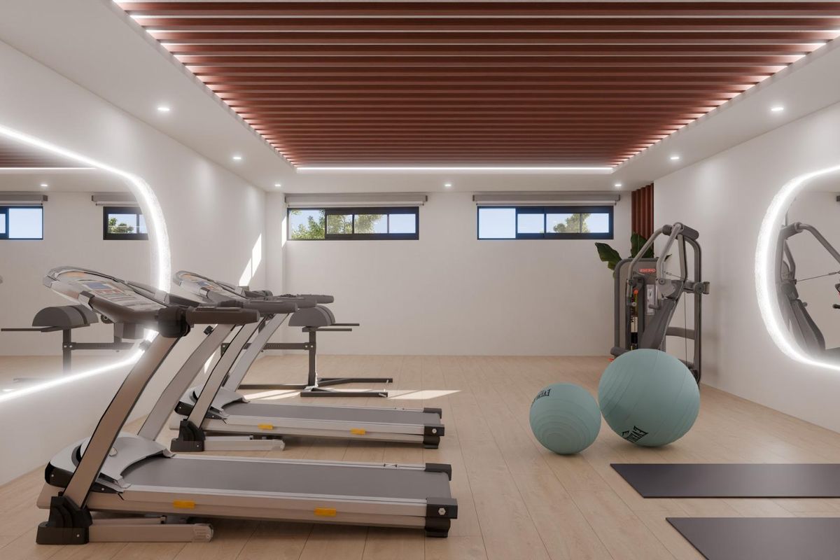 Heldere gymruimte met loopbanden en fitnessapparatuur in een townhouse, gelegen in Mijas, Costa del Sol.