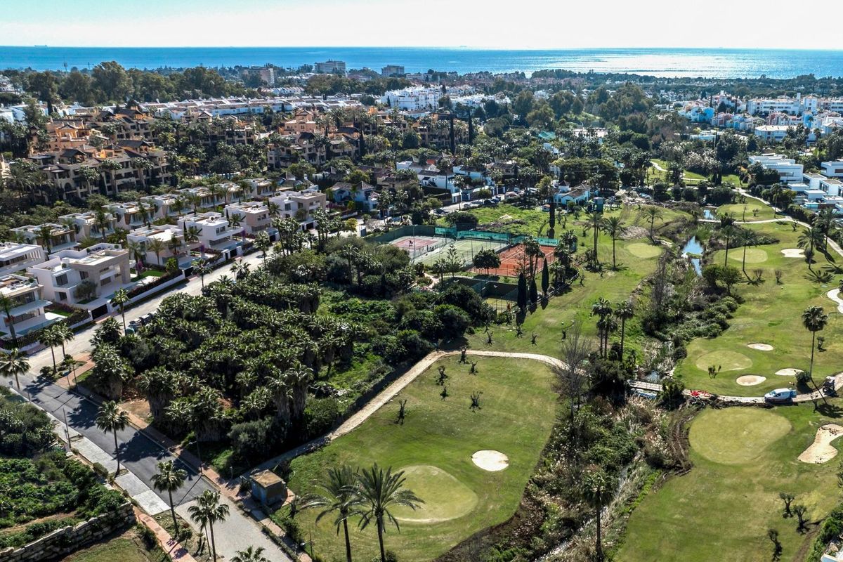 Luchtfoto van Estepona, met weelderige golfbanen en woongebieden nabij de zee.