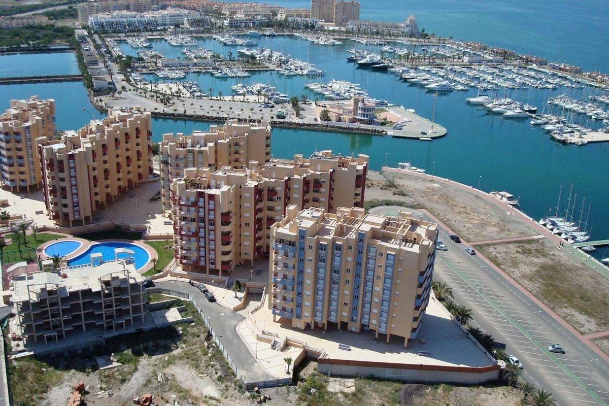 Luchtfoto van een modern appartementencomplex met zwembad bij de jachthaven in La Manga, Costa Calida.
