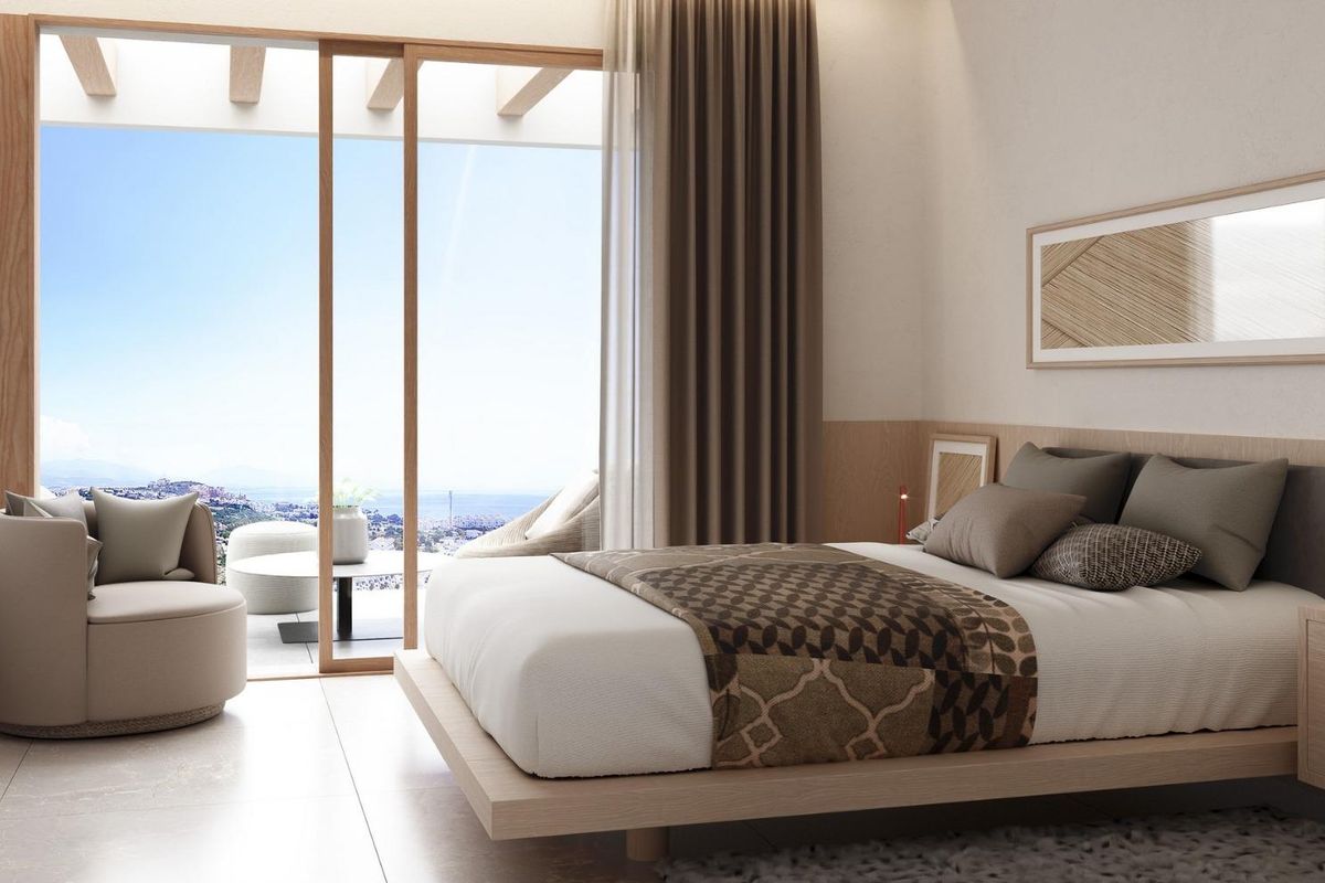 Heldere slaapkamer in een stadswoning in Manilva, Costa del Sol, met een comfortabele inrichting en toegang tot het terras.