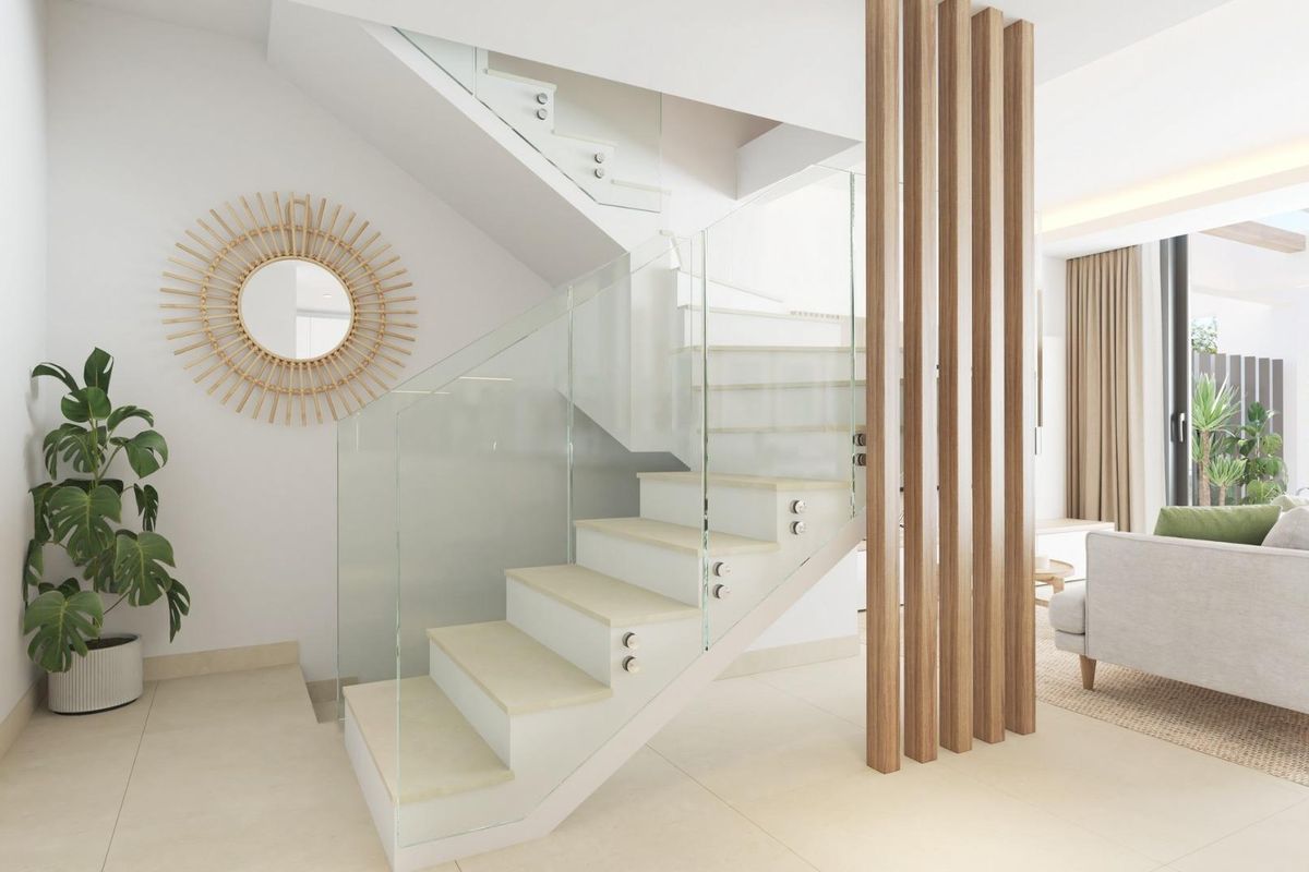 Interieur van een 3-slaapkamer herenhuis in Mijas, met een moderne trap en woonkamer in neutrale tinten en veel natuurlijk licht.