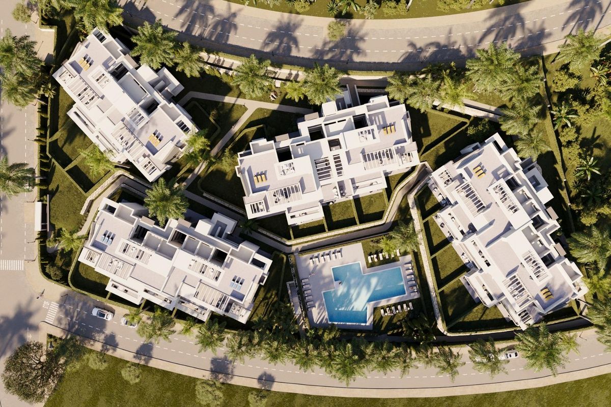 Bovenaanzicht van een luxe penthousecomplex met een zwembad en aangelegde tuinen in Estepona, Costa del Sol.