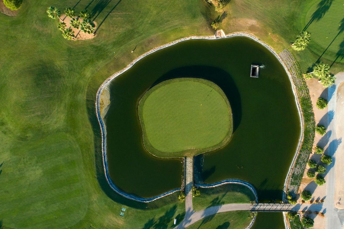 Luchtfoto van een cirkelvormige vijver omringd door groen in Pilar de La Horadada, Costa Blanca Zuid.