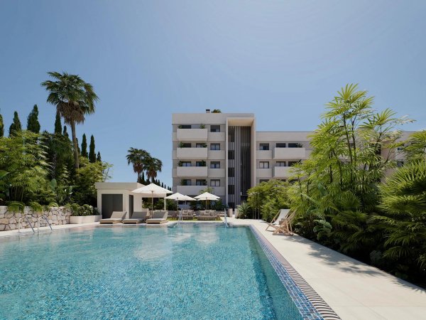 Modern appartementencomplex met een zwembad, omgeven door tropische planten in Estepona, Costa del Sol.