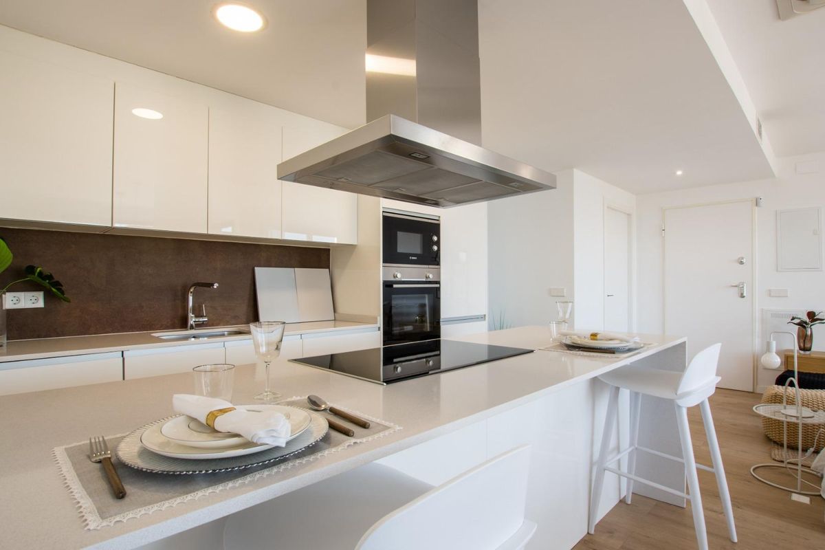 Moderne keuken met eiland en eetopstelling in een een-slaapkamer appartement in Villajoyosa.