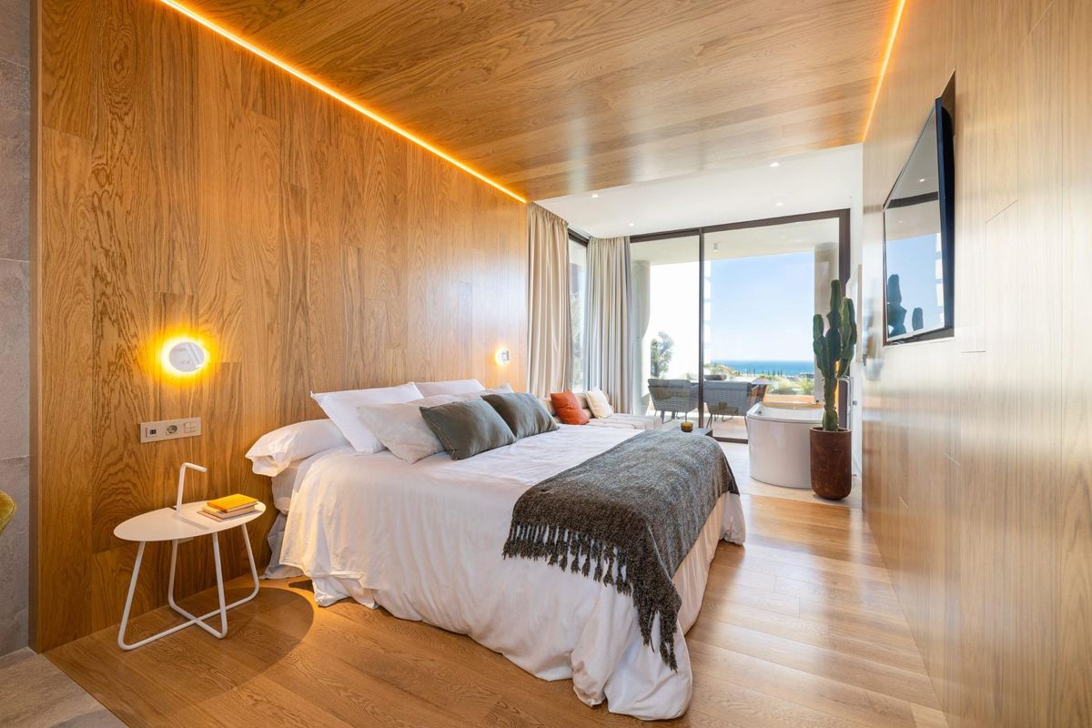 Gezellige slaapkamer met houten accenten en uitzicht op zee in een 2-slaapkamer penthouse in Fuengirola, Costa del Sol.