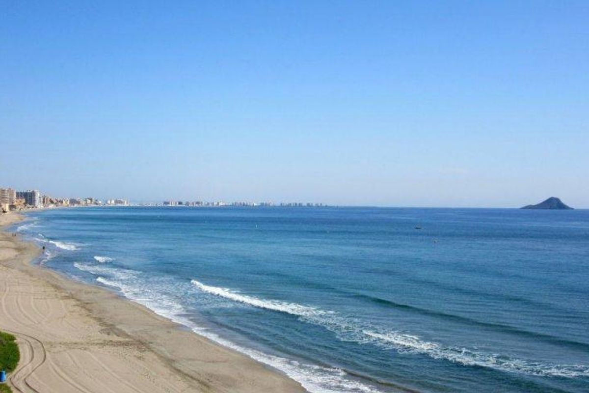 Panoramisch uitzicht op het strand met goudkleurig zand en helder water langs de kust van Costa Calida.