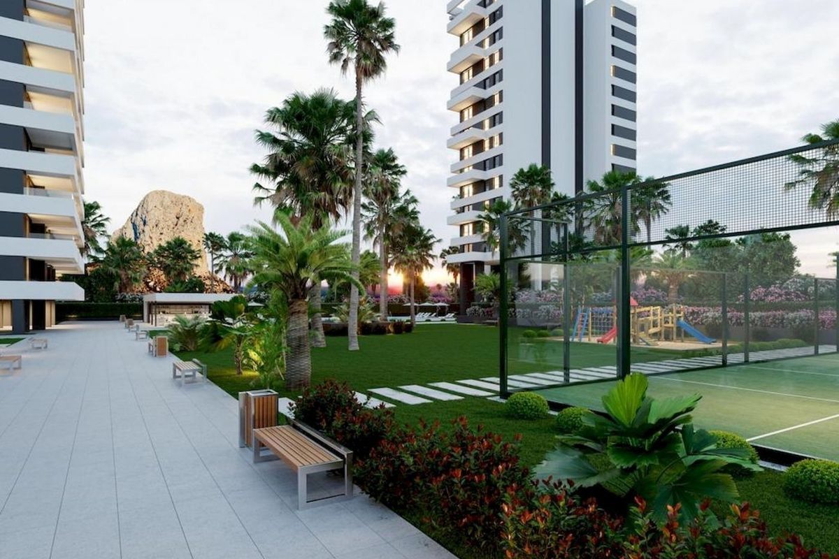 Mooie landschapsarchitectuur rond penthouses in Calpe, met recreatiegebieden en een speeltuin.
