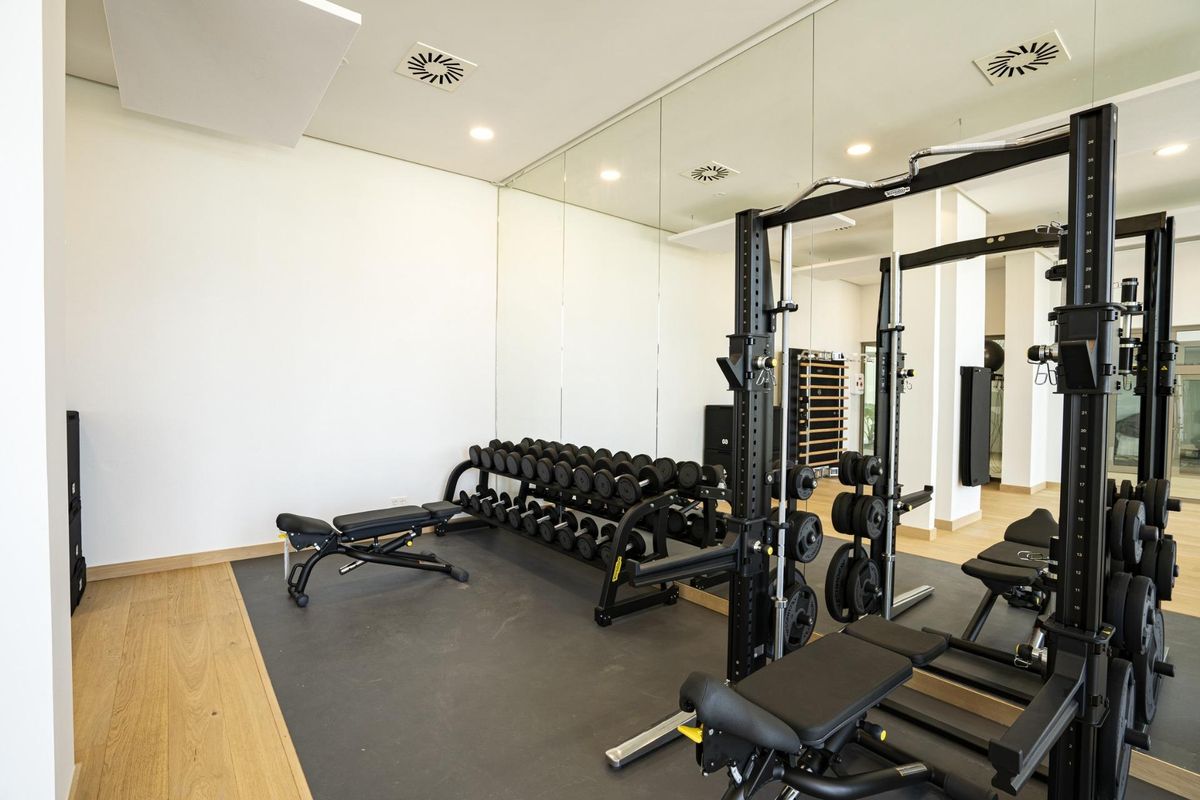 Goed uitgeruste sportschool met gewichten en bankjes in het complex in Benahavís.