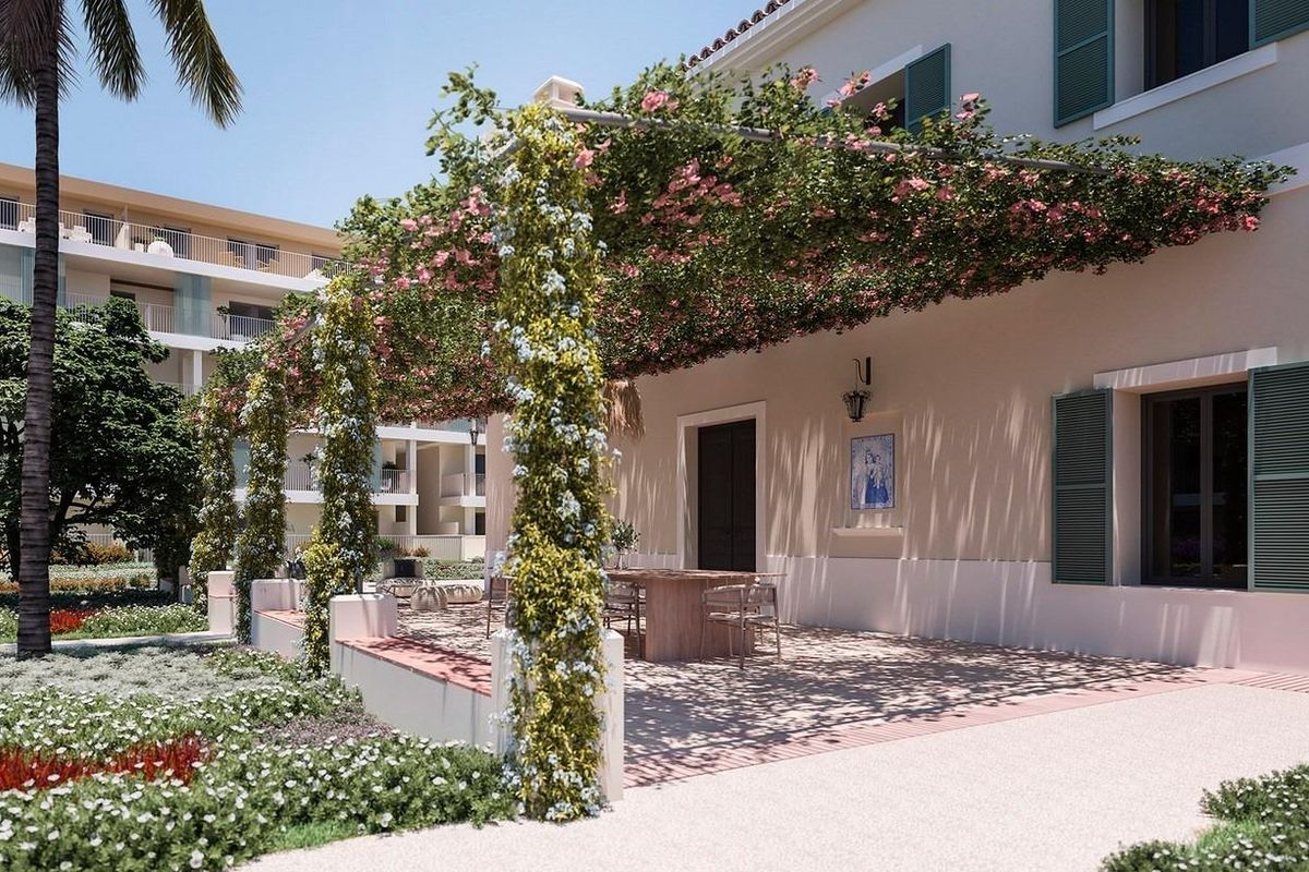 Outdoor dining area with green vines and flowers near modern apartments in Denia, Costa Blanca North.