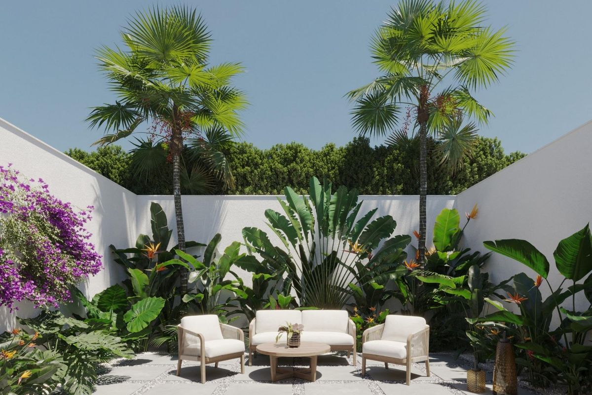 Privé zitgedeelte in de tuin van een villa in Finestrat, omringd door tropische planten en bloemen.