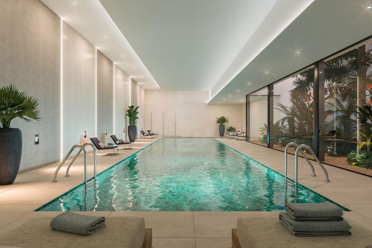 Binnenzwembad met weelderige planten in een luxe appartementencomplex in Marbella, Costa del Sol.