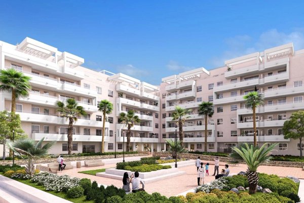 Buitenzicht op een modern 4-slaapkamer appartementengebouw in Marbella, Costa del Sol, met aangelegde tuinen.