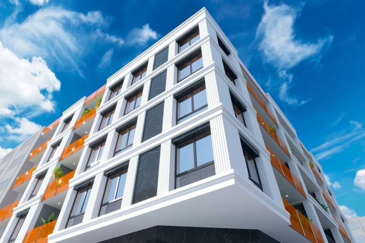 Hoekzicht van een hedendaags penthouse gebouw dat levendige kleuren reflecteert in de zon in Torrevieja, Spanje.