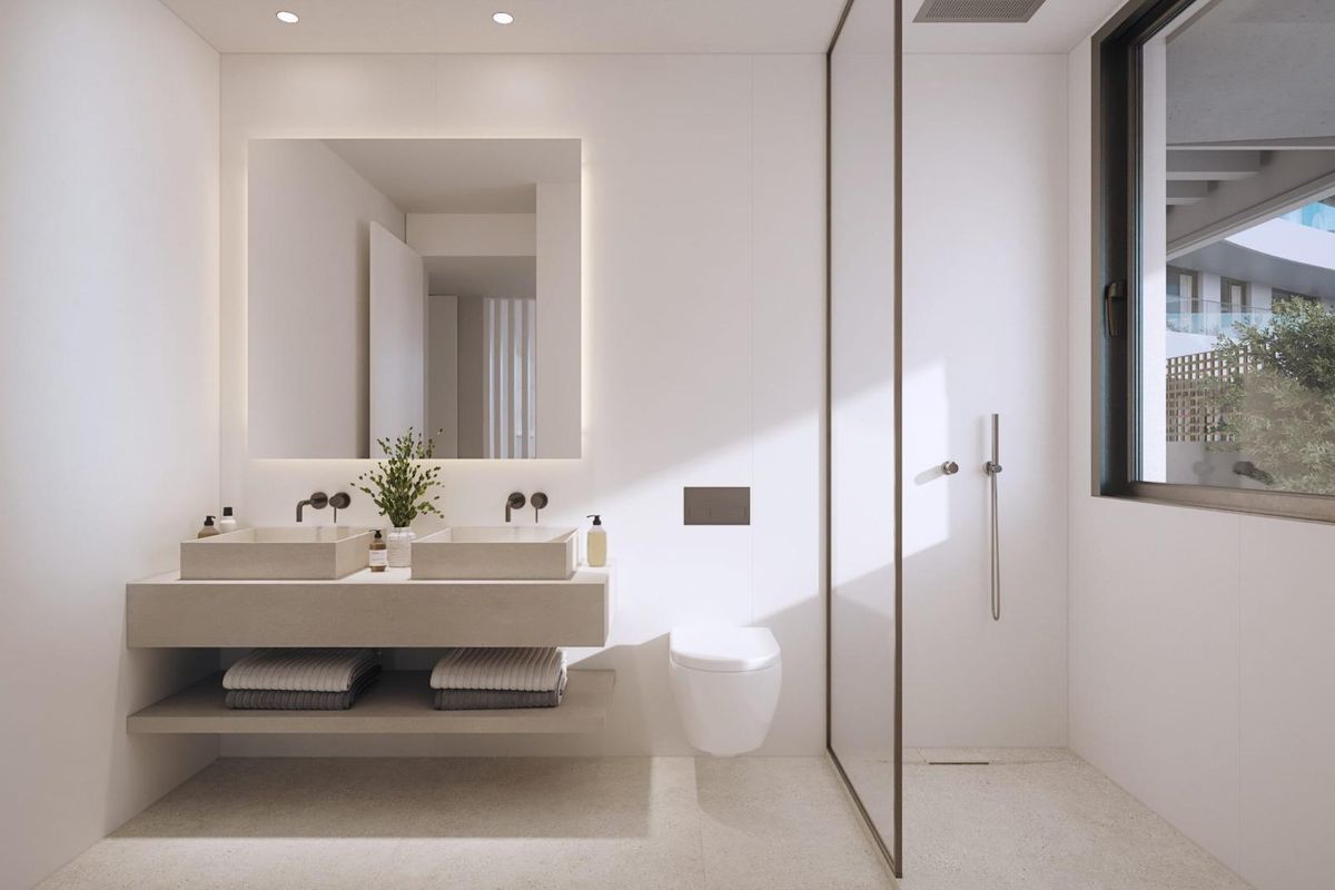 Moderne badkamer in een appartement in Málaga met minimalistisch ontwerp, natuurlijke lichtinval en stijlvolle armaturen.