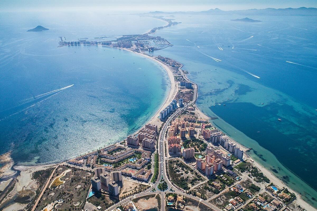 Een adembenemend luchtbeeld van de kustlijn in Costa Calida, met gebouwen en blauwe wateren.