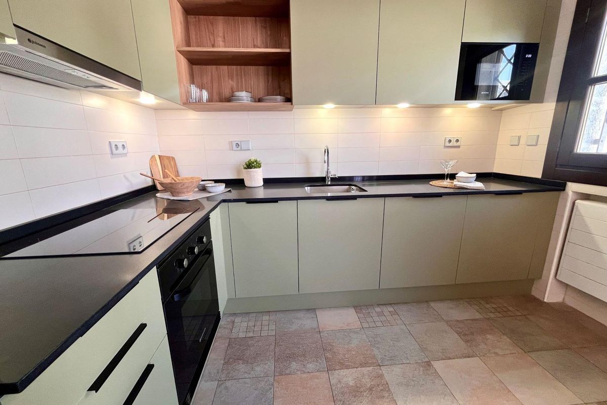 Contemporary keuken met olijfgroene kasten en moderne apparaten in een townhouse in Sucina.