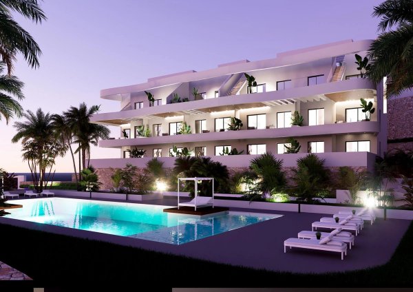 Modern penthouse gebouw met palmbomen en zwembad bij het vallen van de avond in Finestrat, Costa Blanca Noord.