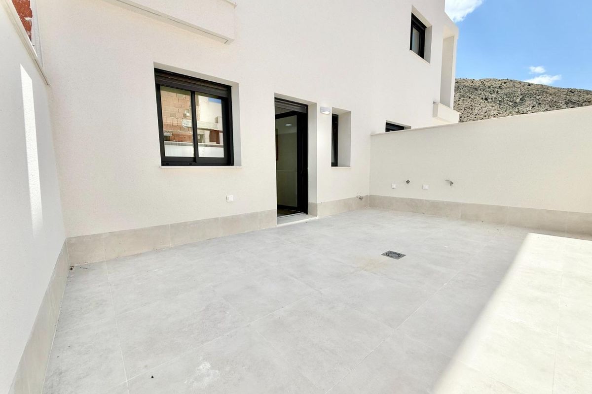 Open buitenpatio naast een town house in Cox, Costa Blanca, klaar voor tuinmeubilair.