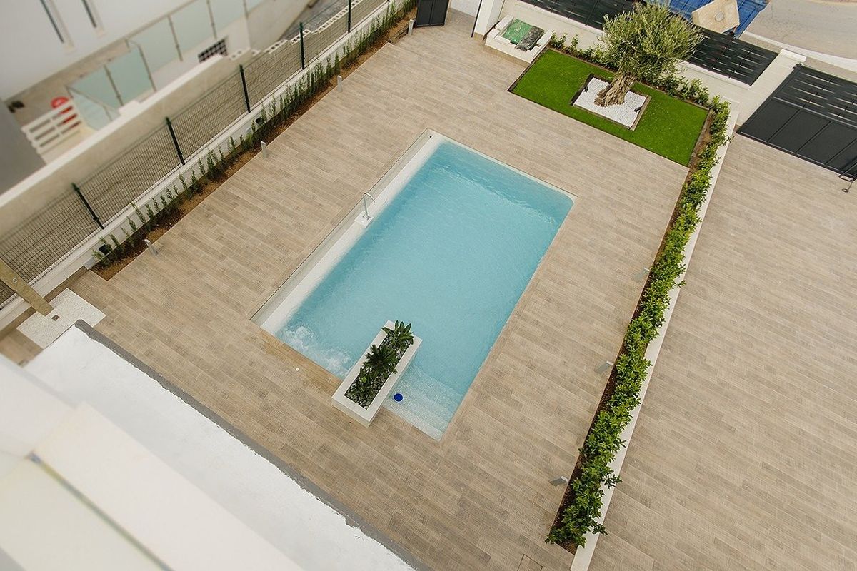 Luchtfoto van het zwembadgebied bij een villa in Cartagena, omgeven door aangelegde tuinen.