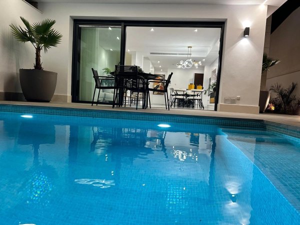 Uitzicht op het zwembad en eetruimte van de villa, moderne buitenleefstijl in San Pedro del Pinatar.