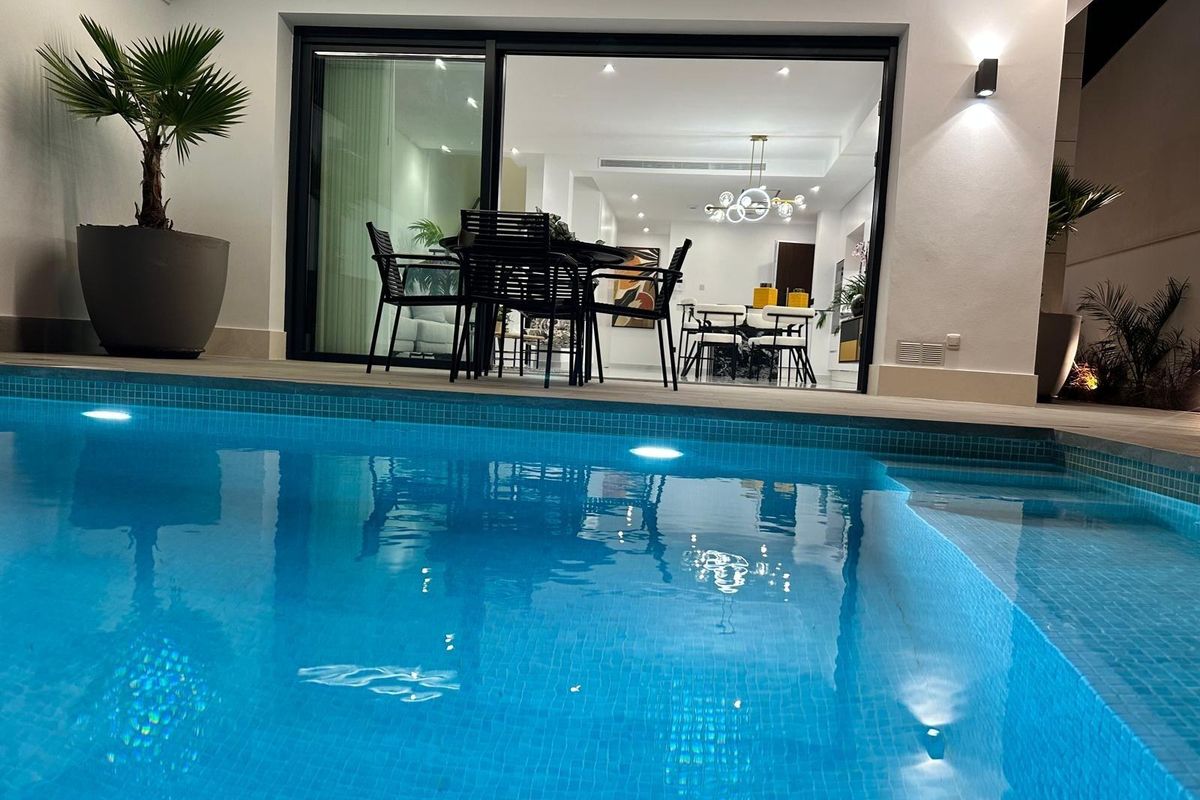 Uitzicht op het zwembad en eetruimte van de villa, moderne buitenleefstijl in San Pedro del Pinatar.