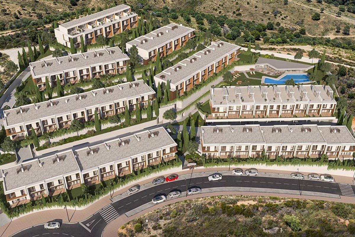 Luchtfoto van een moderne townhouse complex met tuinen en zwembad in Mijas, Costa del Sol.