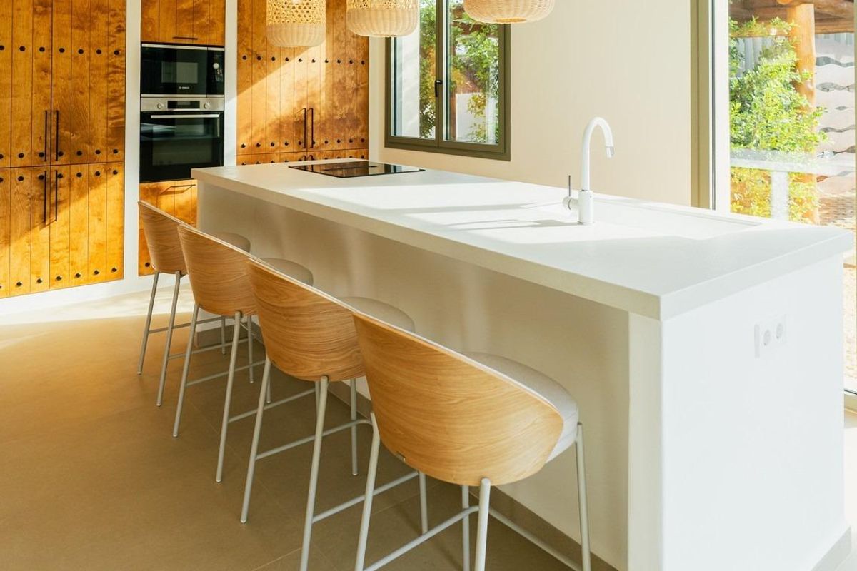 Stijlvolle keuken met houten accenten en een ontbijtbar in de villa in Jávea.