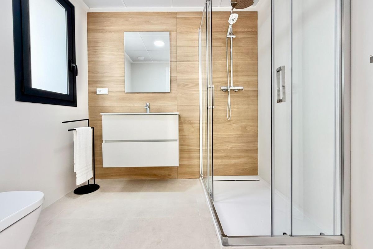 Strakke doucheruimte met natuurlijke tinten, ontworpen voor comfort in een town house in Cox, Costa Blanca.