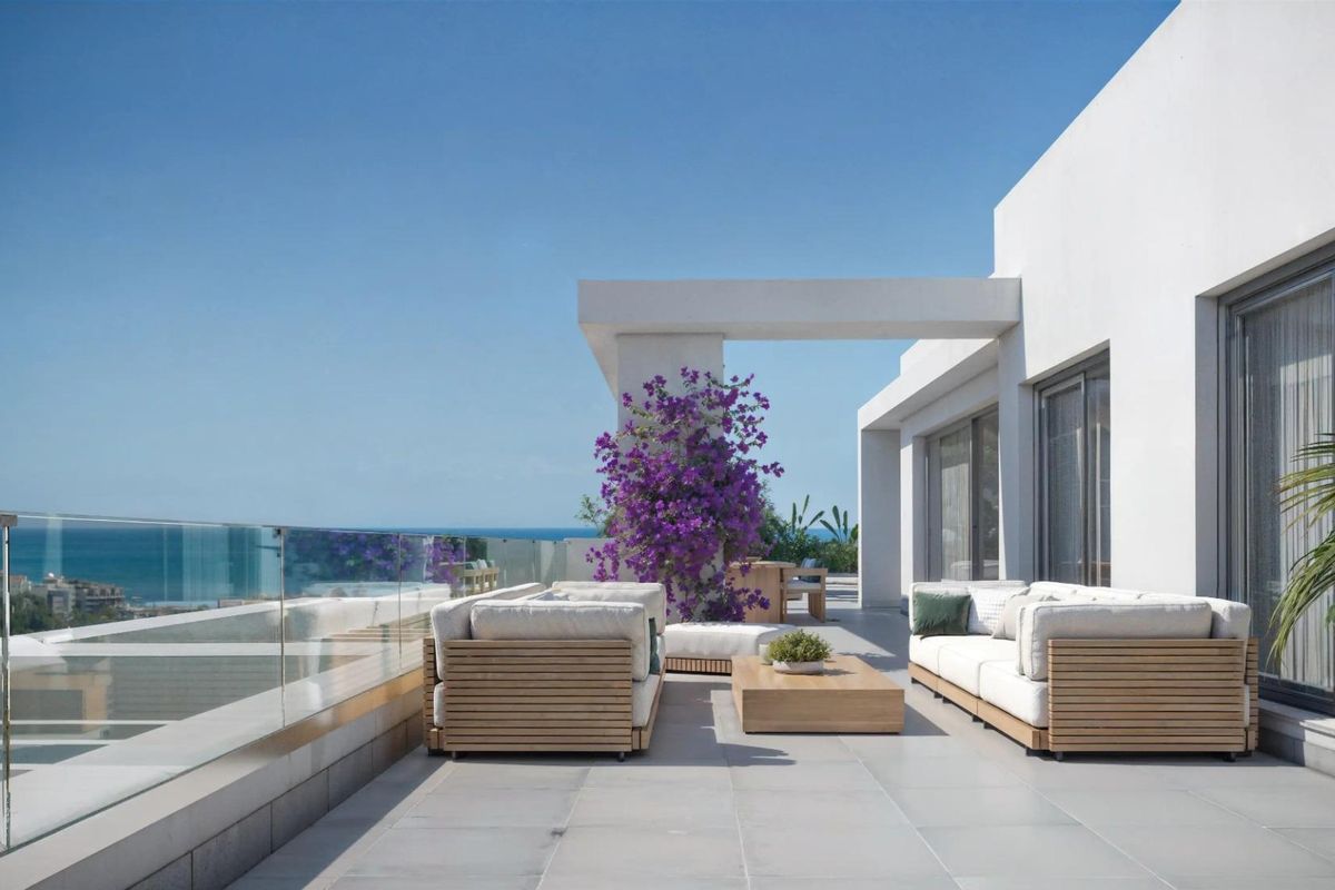 Heldere terras met moderne zitplaatsen en uitzicht op de oceaan in Estepona, Costa del Sol, perfect voor buitenleven in een 3-slaapkamer appartement.