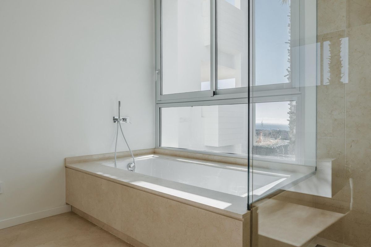 Luxe badkuip in een lichtgevende badkamer, onderdeel van een 3-slaapkamer appartement in Benahavís, met prachtig ontwerp.