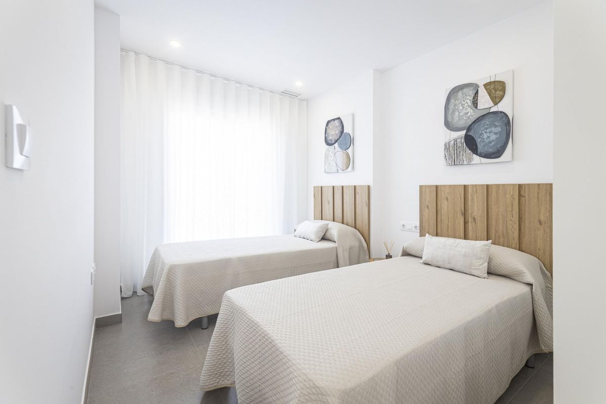 Stijlvolle tweepersoons slaapkamer met natuurlijk licht en moderne decoratie in een appartement in La Manga del Mar Menor.