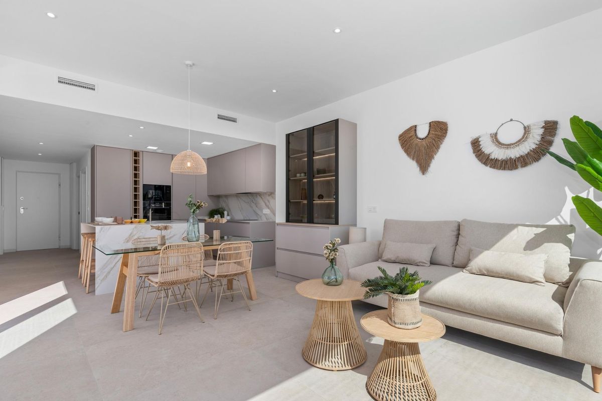 Heldere woonkamer met stijlvolle inrichting, natuurlijk licht en een open keuken in de villa in Los Alcazares.