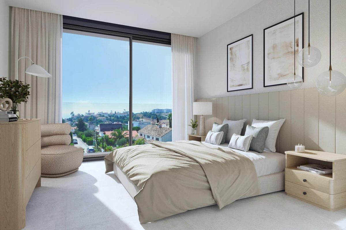 Helder slaapkamer in het Estepona appartement, met grote ramen en uitzicht over het landschap.