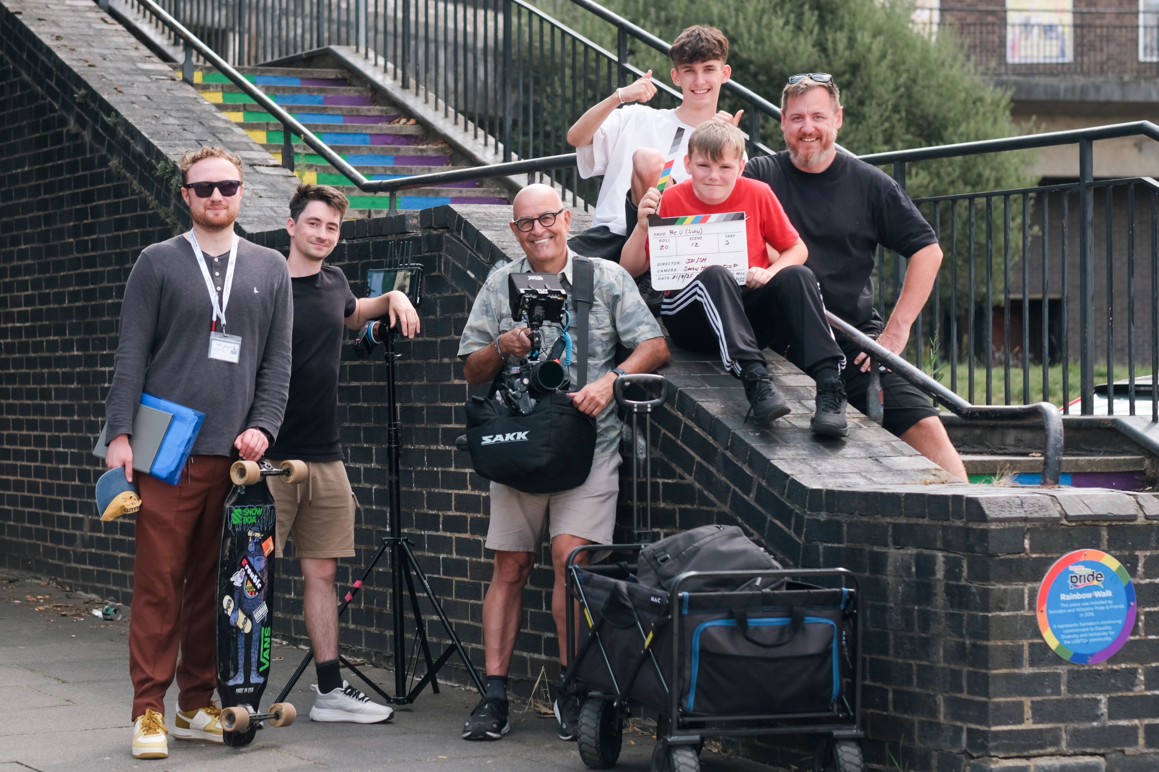 BeU Swindon film crew and young cast posing with a clapperboard by a brick wall