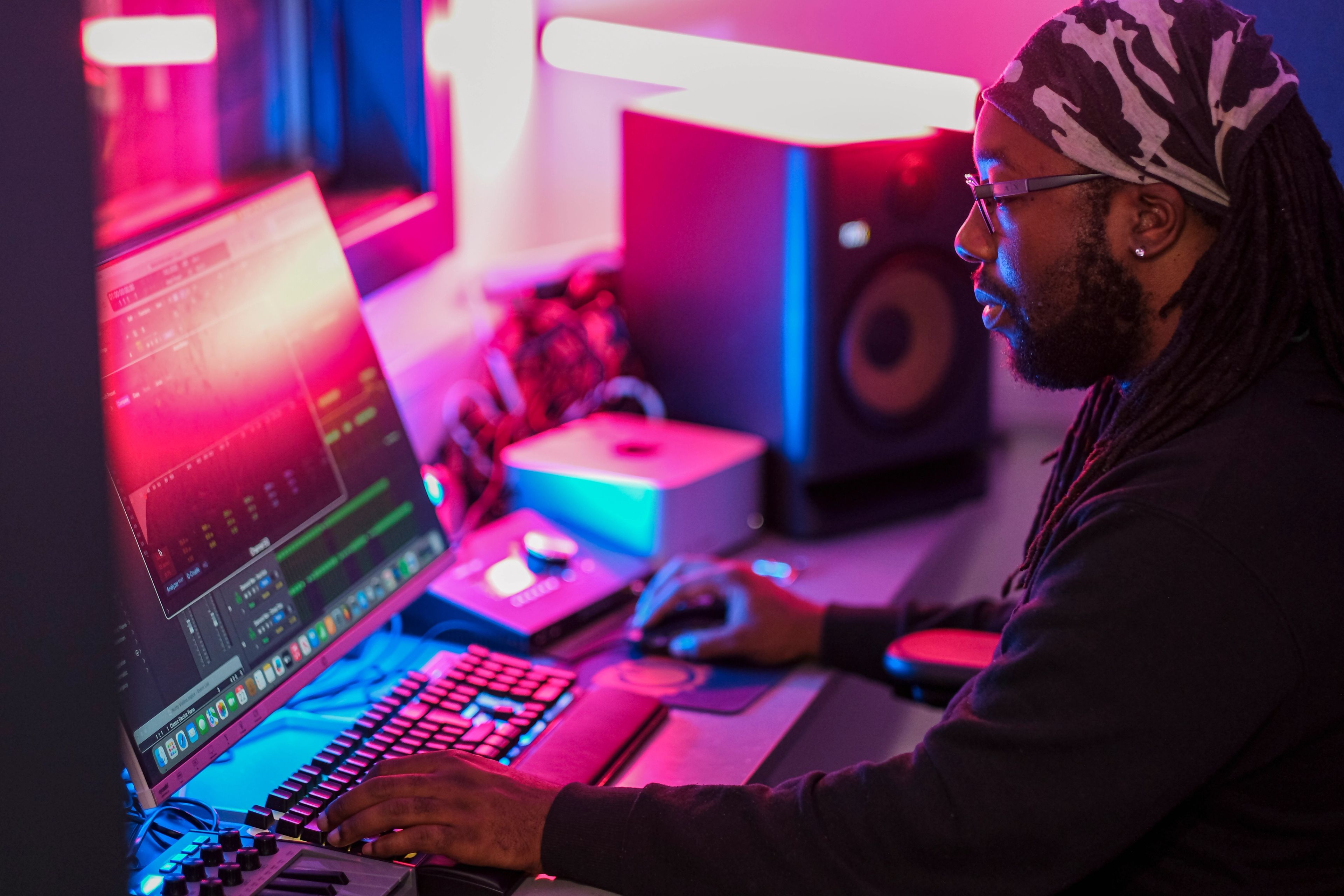 Young music producer working at a neon-lit studio desk during the BeU Swindon campaign shoot